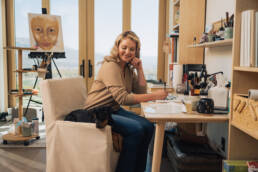 Katherine Heigl's Artwear: Katherine Heigl sitting at a desk in her art studio in Utah with one of her rescue puppies.